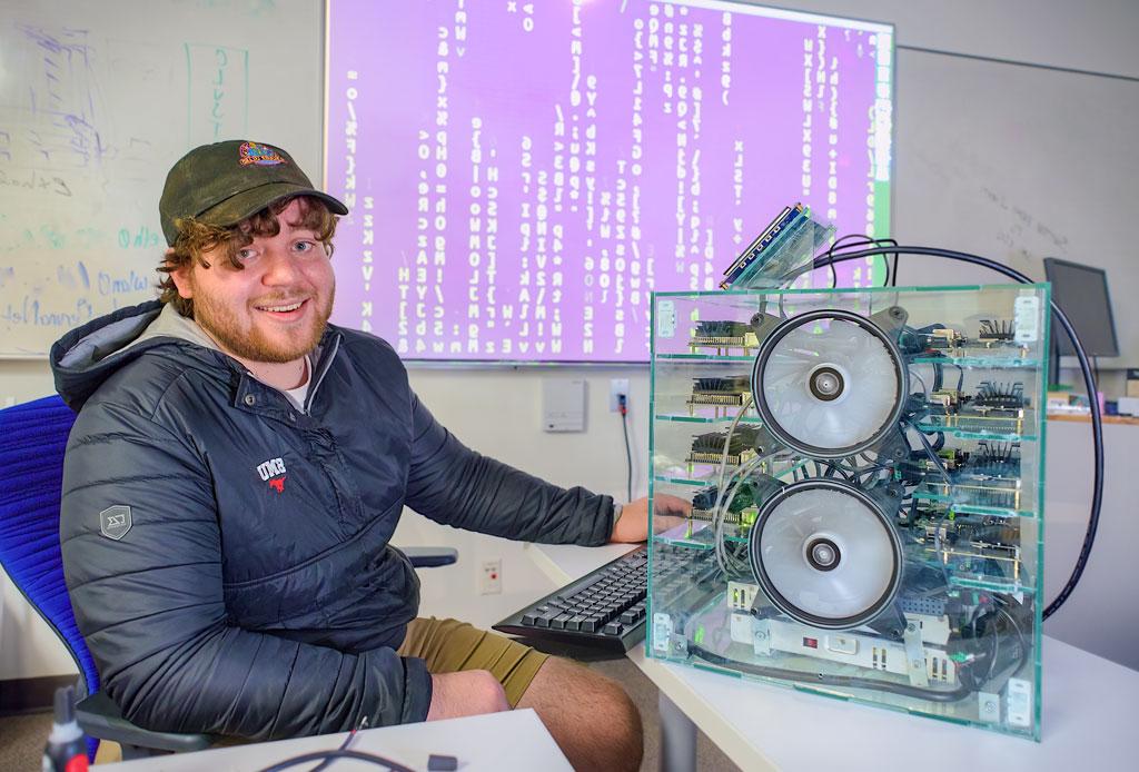 A photo of Conner Ozenne next to the "baby super-computer"