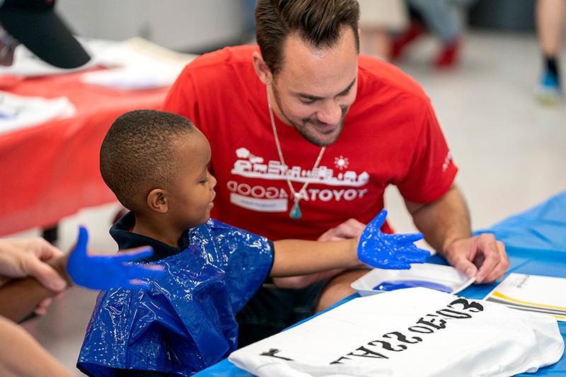 A person and child fingerpaint at the West Dallas STEM school